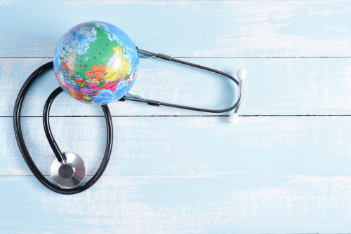 Estetoscópio e globo em um fundo de madeira, simbolizando o mês mundial da saúde.