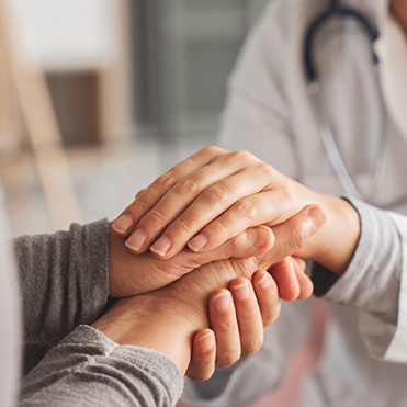 Profissional de saúde segura mãos de paciente em gesto de cuidado.