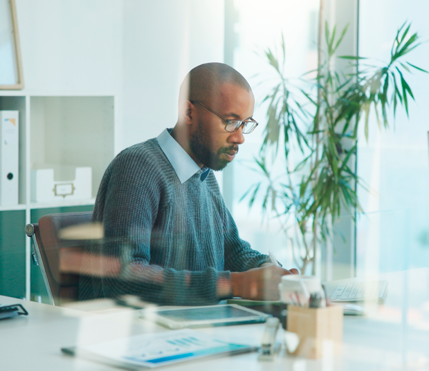 Profissional trabalhando concentrado em escritório moderno e organizado.